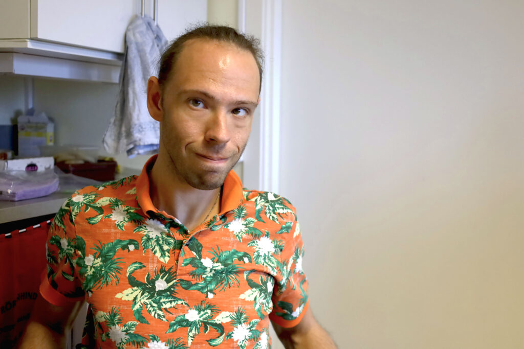 Närbild på Erik Dahlström framför diskbänken. Han tittar in i kameran och ler lite blygt.