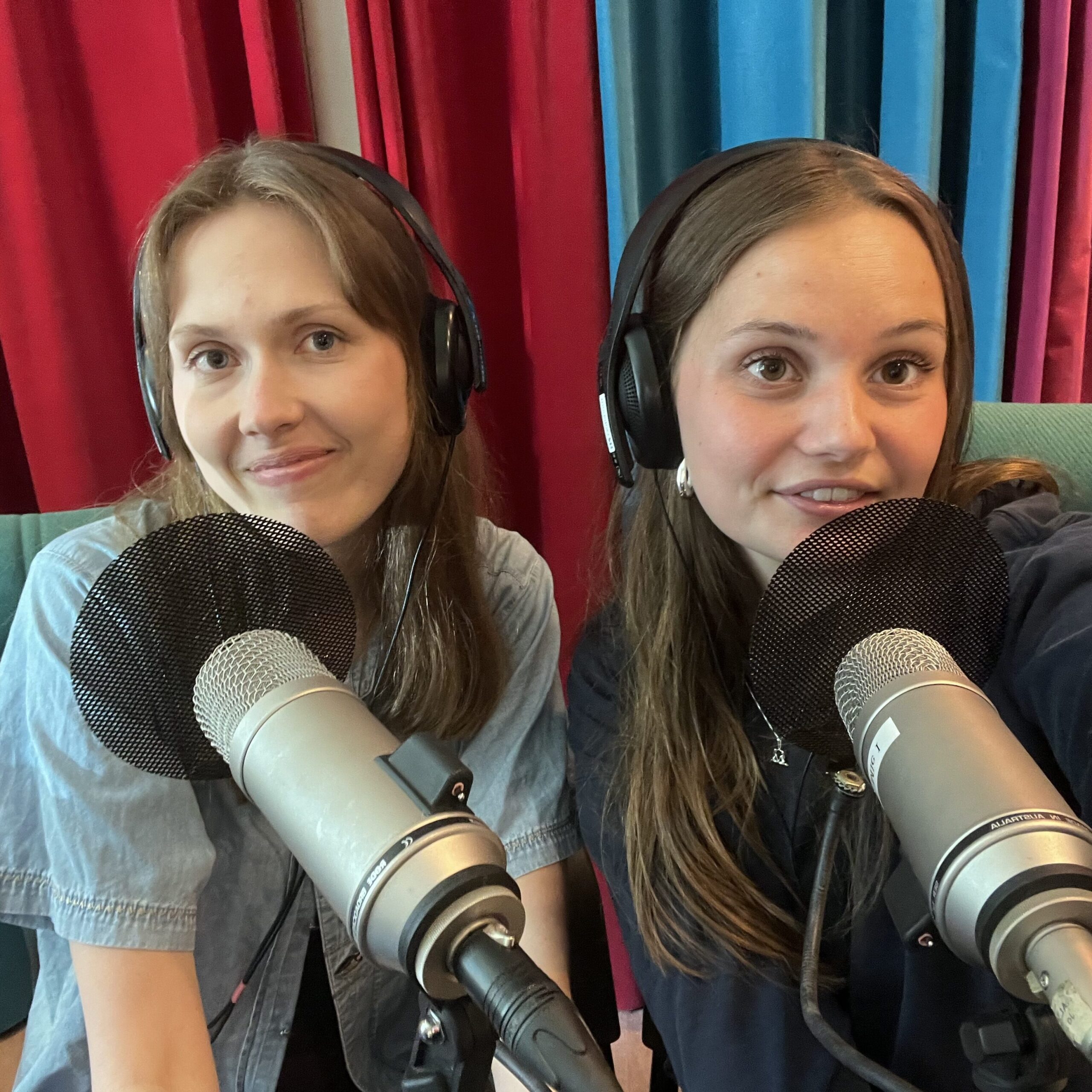 Elsa Larsson, till vänster, och Maja Matsdotter, till häger, ler mot kameran framför varsin mikrofon.
