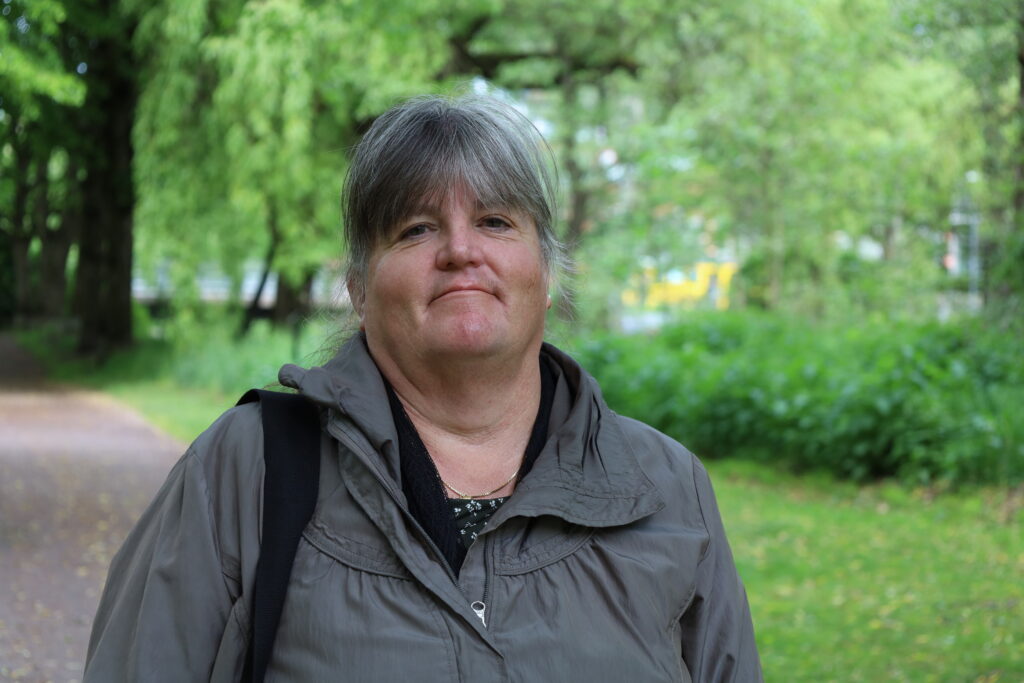 Katarina Evenseth ler mot kameran, iklädd en grå jacka. Bakgrunden är suddig.