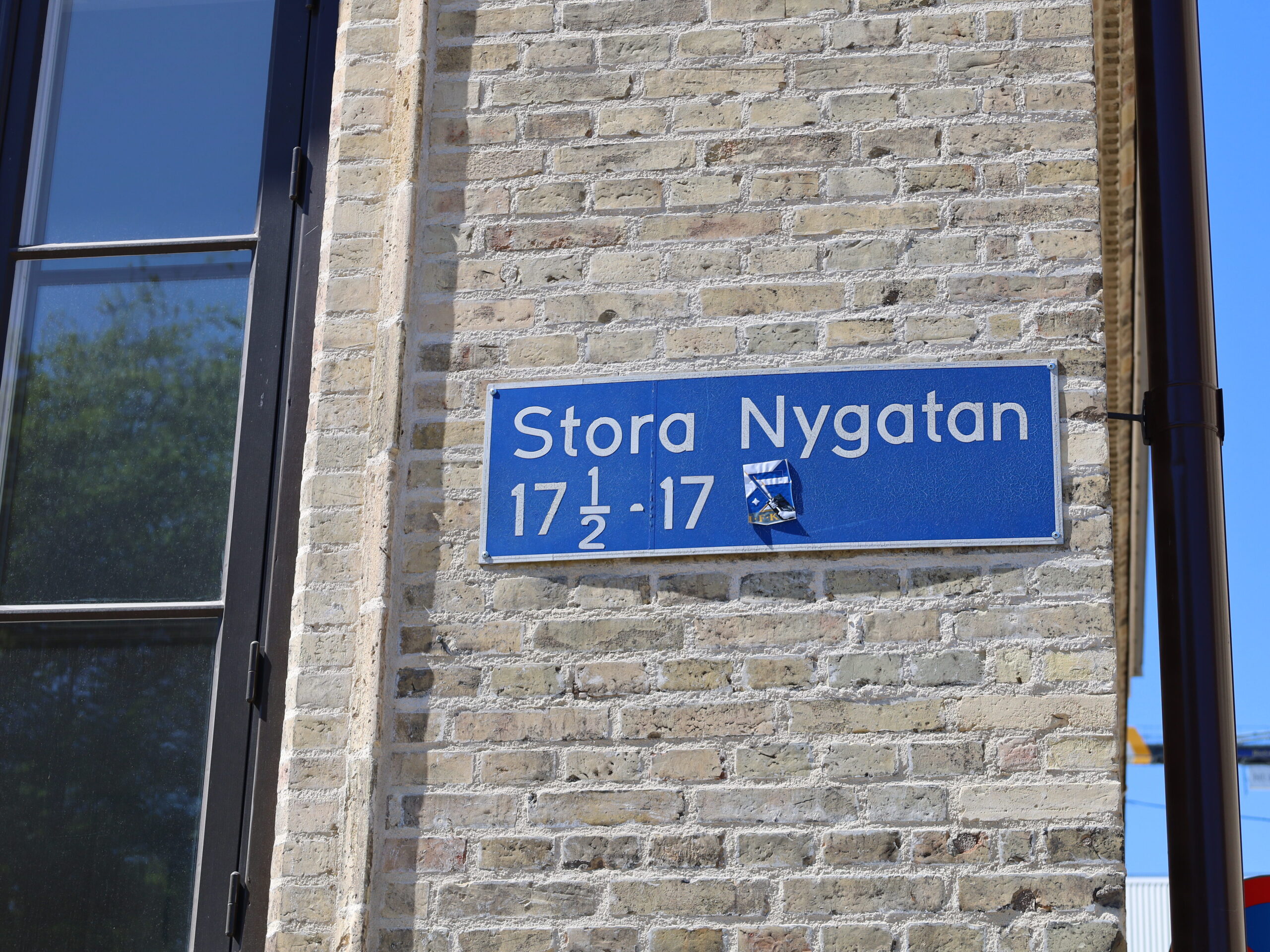 Gatuskylt. Texten lyder: "Stora Nygatan 17 1/2 - 17".