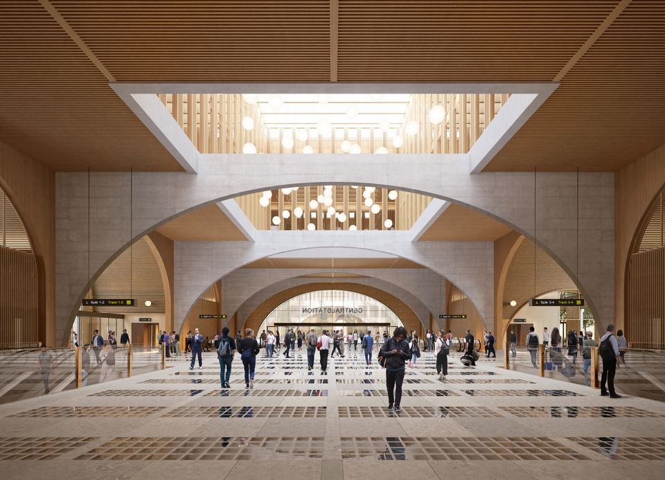 Illustration inifrån Grand Central. Människor rör sig runt under stora runda valv, och bilden lyses upp av massor av runda lampor som hänger ner från taket.
