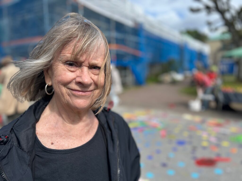 Kerstin Bratt, en blond kvinna iklädd en svart tröja, ler mot kameran. Bakgrunden är suddig.