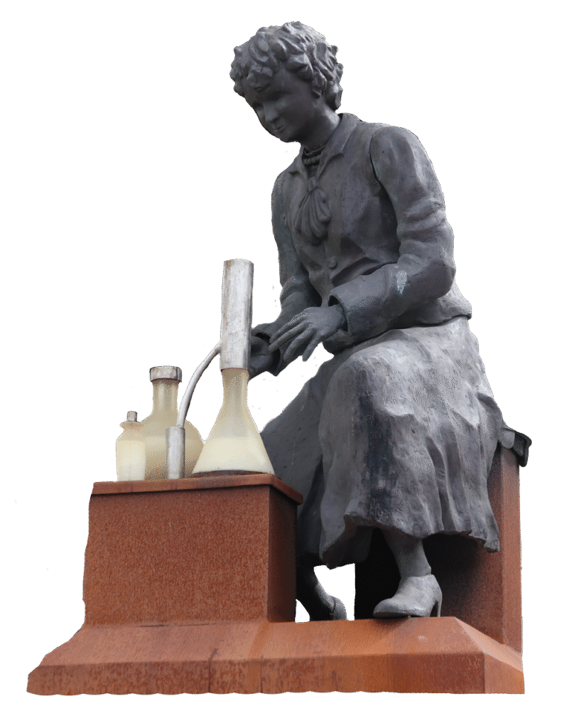 Staty föreställande Vera Sandberg, iklädd blus och kjol, som sitter framför trattar och behållare.